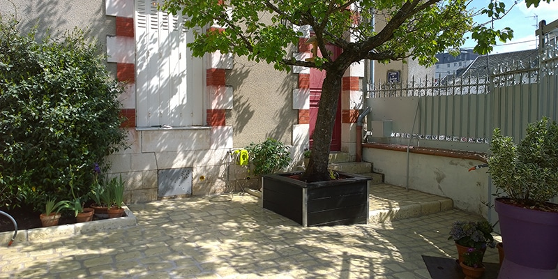 Création d’une cour pavée en pierres naturelles avec bordures et jardinières intégrées - Paysagiste Lantana Jardécor - Orléans, Loiret (45)